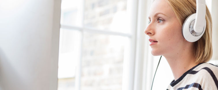 Frau mit Kopfhörer hört Podcast